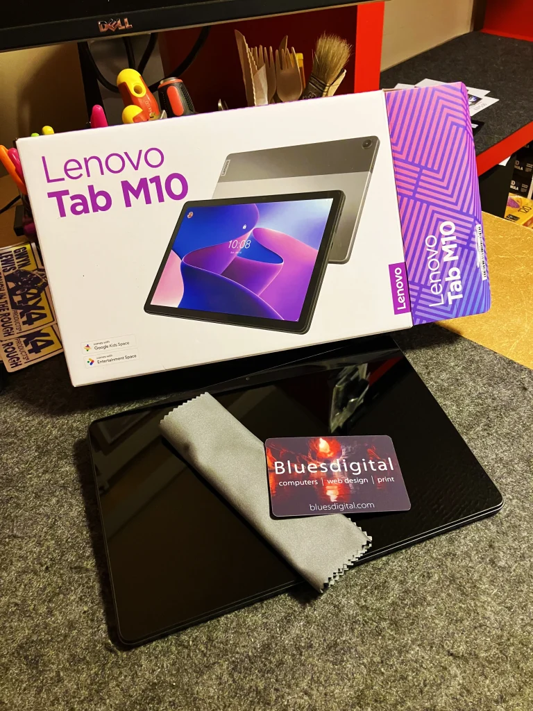 Lenovo Tab M10 tablet shown next to its box on a desk.