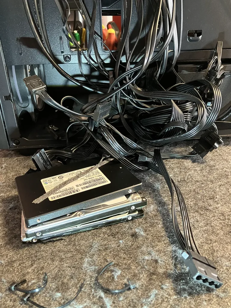 A top-down view looking into the main chamber of the PC case, revealing chaotic, incomplete wiring forcibly shoved into the frame. This image highlights the bad cables and terrible workmanship inside the Budget Gaming PC that was brought to Bluesdigital after it failed to boot.