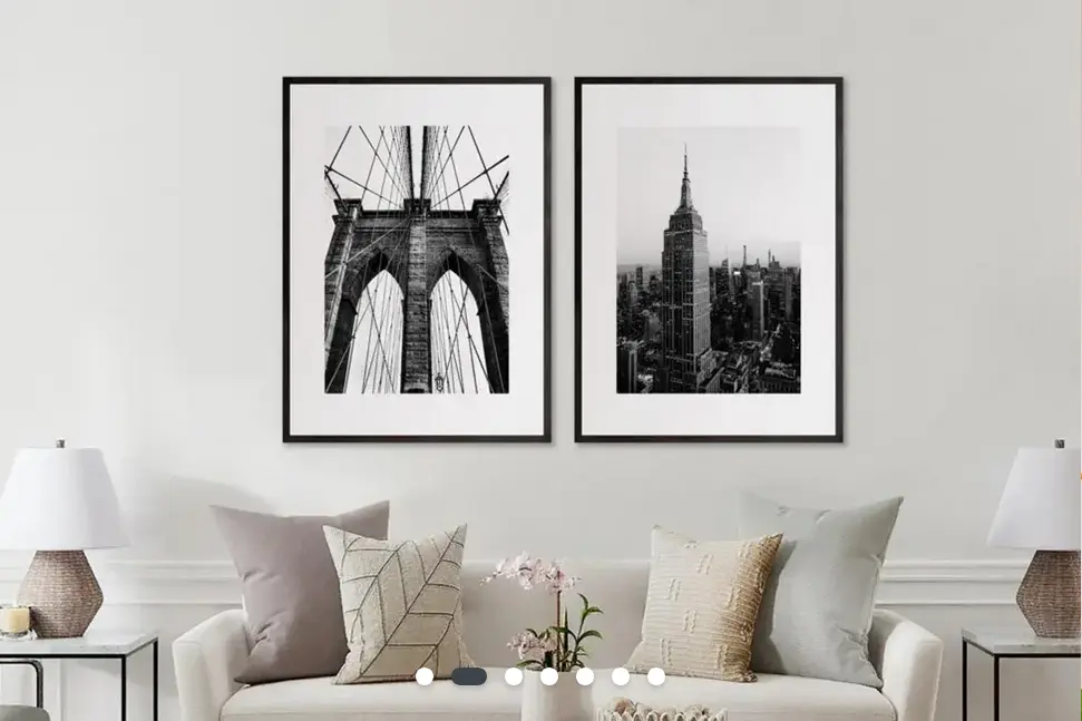 A photo of a room with a sofa and two wicker lamps. On the wall are two black-and-white photo prints of famous architecture - they are very high quality.