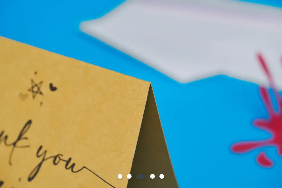 The close-up of the corner of a printed card showing the fold in detail.