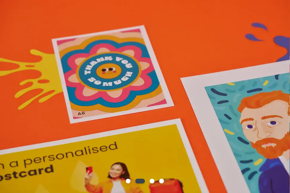 A stylised photo of three different postcards against an orange background with artistic paint splashes.
