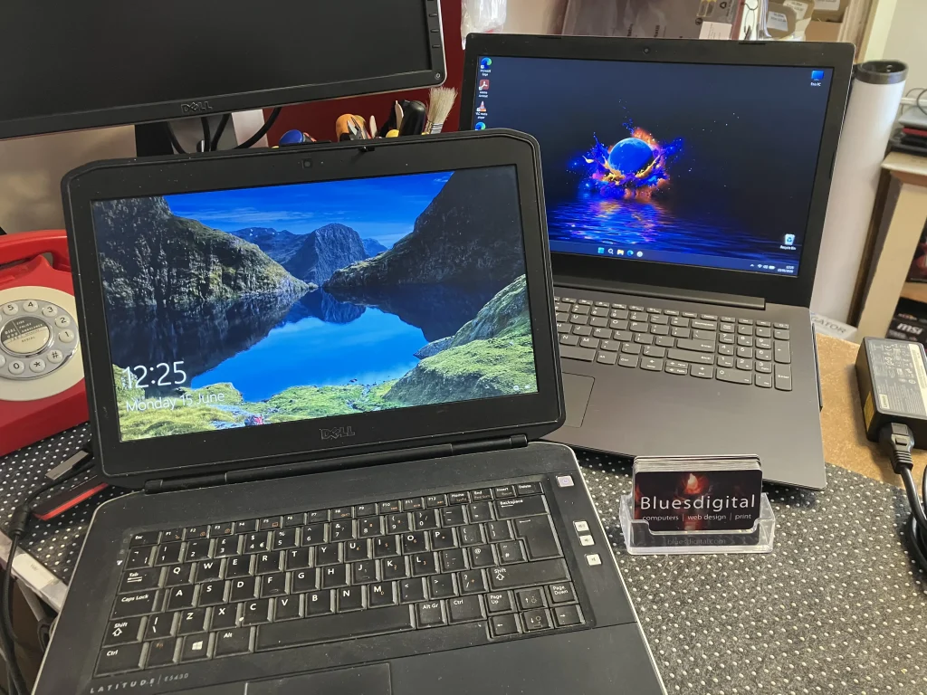 A photo of the old Dell laptop in front with the refurbished Lenovo laptop behind, looking all shiny and new.