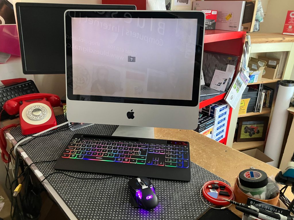 A photo of the classic Mid-2007 Apple iMac 20-inch desktop computer with a faded, blank screen sitting on a display shelf inside the Bluesdigital repair workshop.