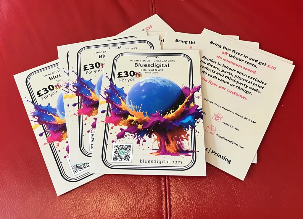 Photo of flyers with £30 off labour on Bluesdigital services. The flyer shows a blue moon bouncing out of a colourful splash from a mobile screen.